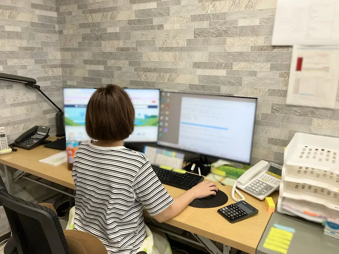パソコンに向かい、寄附者様からのお問い合わせに対応するスタッフ
